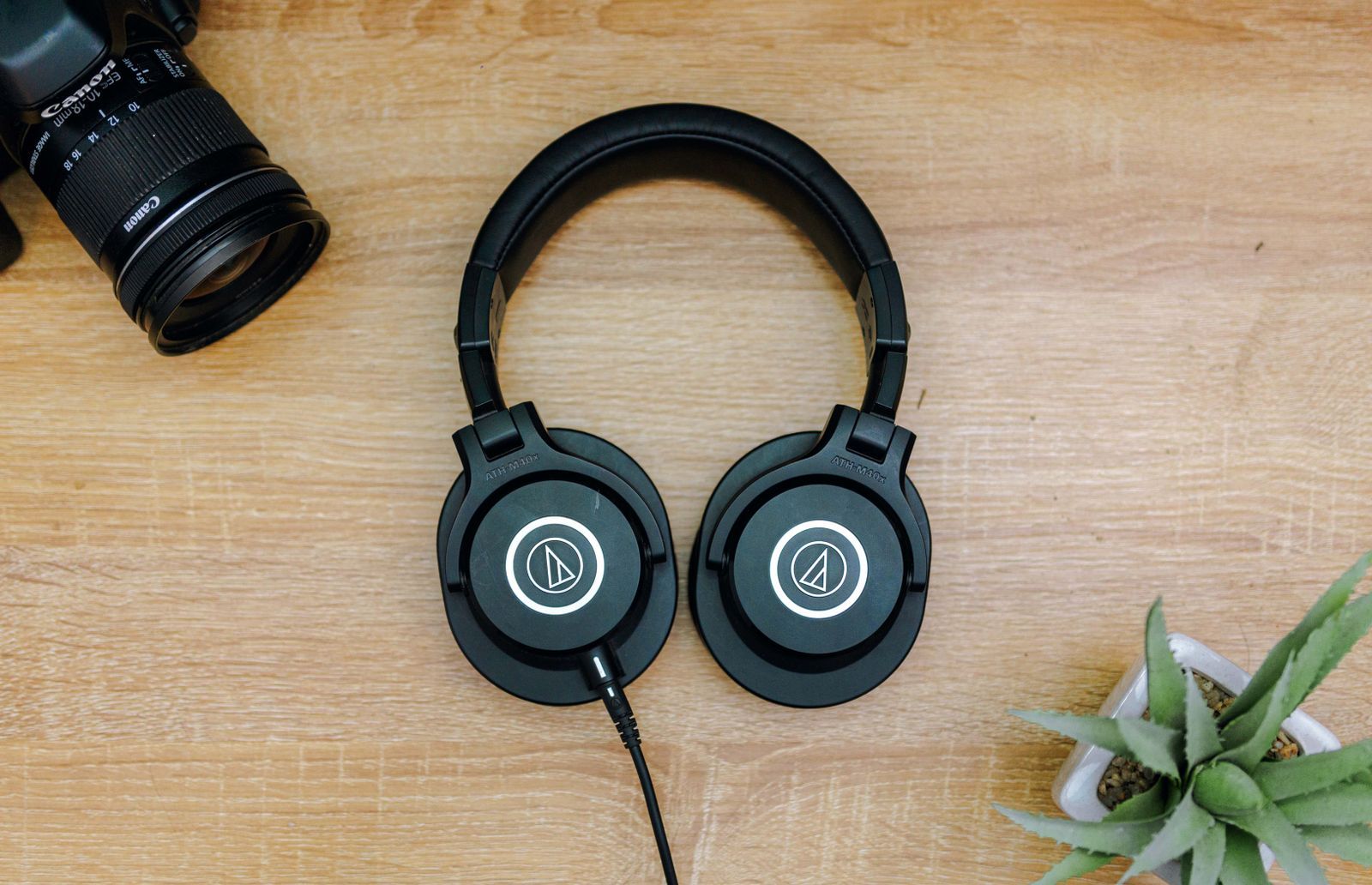 Auriculares y cámara de fotos sobre una mesa de madera